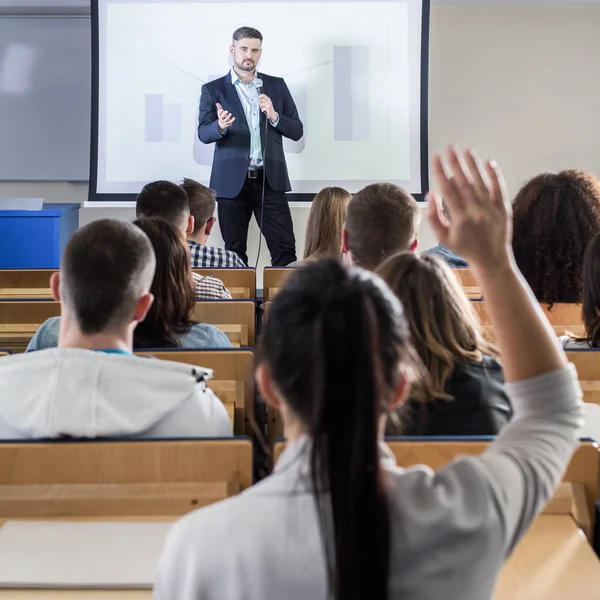 Student raising hand during seminar — Stock Photo, Image