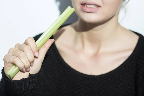 Анорексична дівчина їсть цибулю-порей — стокове фото