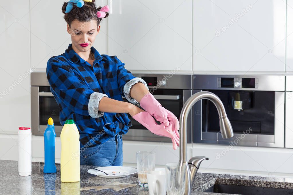 Unhappy woman cleaning big kitchen 