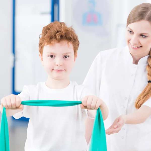 Physiothérapeute pédiatrique faisant de l'exercice avec un garçon — Photo