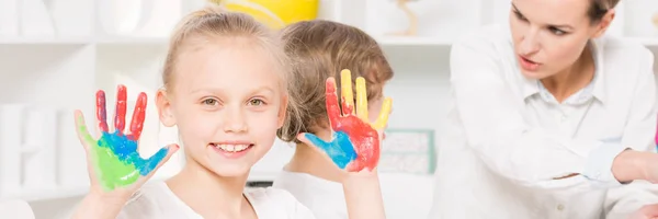 Chica con coloridas manos pintadas — Foto de Stock