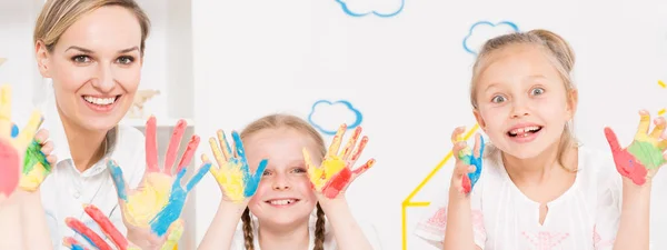 Meninas mostrando as mãos pintadas cor — Fotografia de Stock