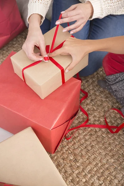 Woman tying red ribbon bow — Stock Photo, Image