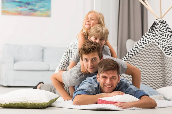 Família deitada uma sobre a outra — Fotografia de Stock