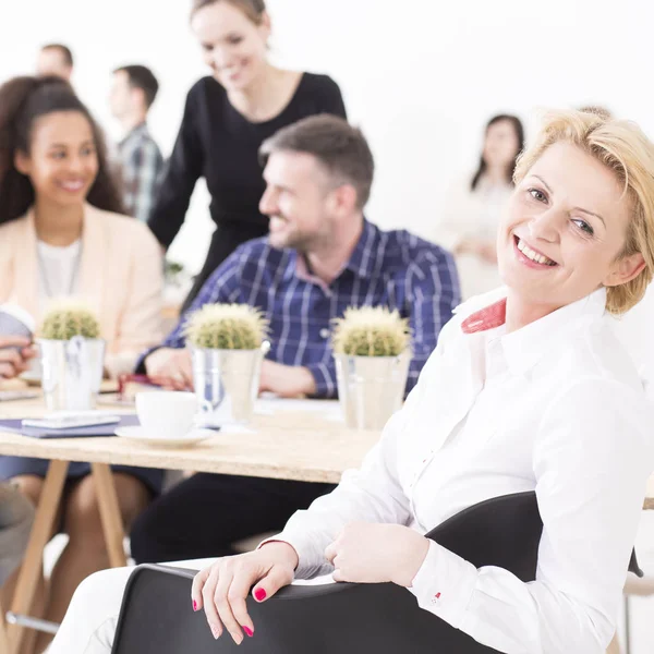 Felices compañeros de trabajo hablando en la oficina —  Fotos de Stock