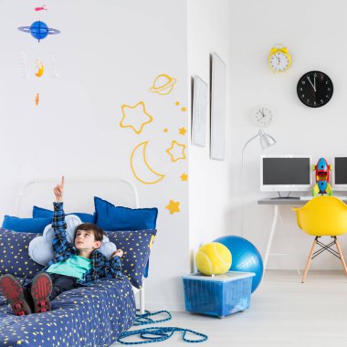 Erkek yatakta yatan ve tavana işaret