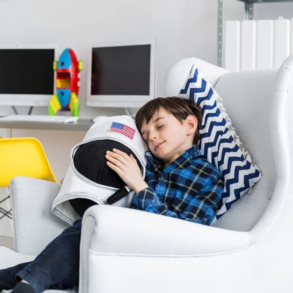 Kleiner Junge sitzt auf einem Stuhl im Zimmer — Stockfoto