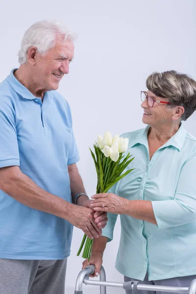 Velho dando flores — Fotografia de Stock