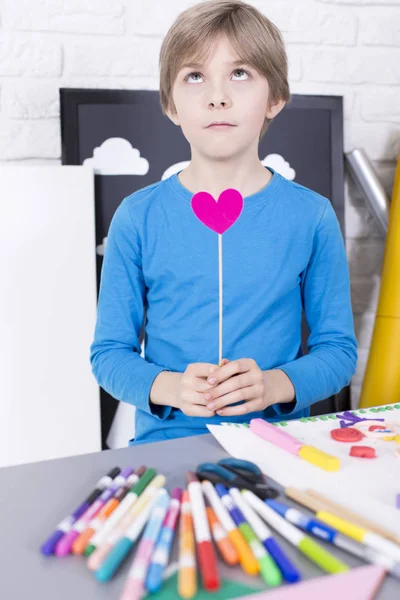 Jongen met stok met papier hart — Stockfoto