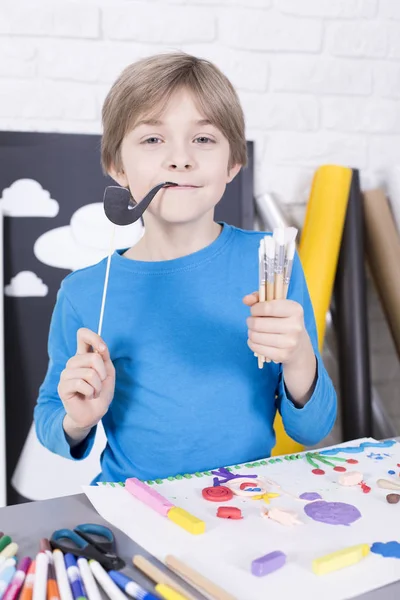 Niño con cepillos y tubo de papel falso en palo — Foto de Stock