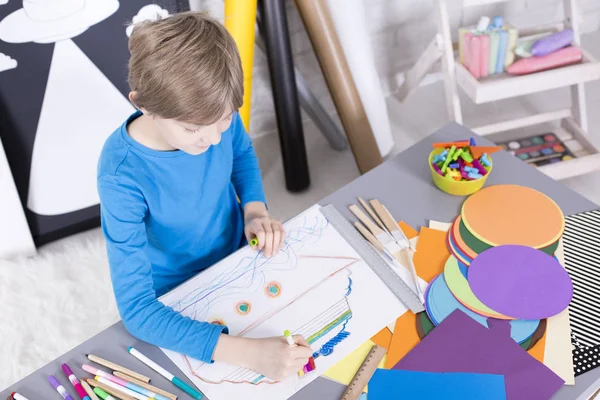 Boy having fun with paper and colored pencils — Stock Photo, Image