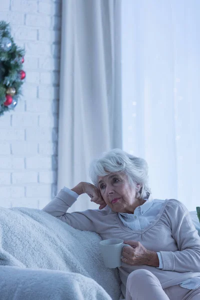 Одинокая пожилая женщина на диване — стоковое фото