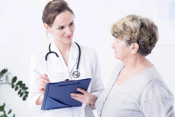 Médecin faisant l'anamnèse avec une femme âgée — Photo