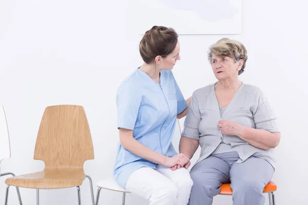 고위 여자 가까이 앉아 간호사 — 스톡 사진