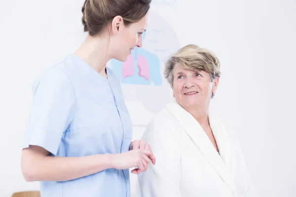 Enfermera joven y anciana en el pasillo del hospital brillante —  Fotos de Stock
