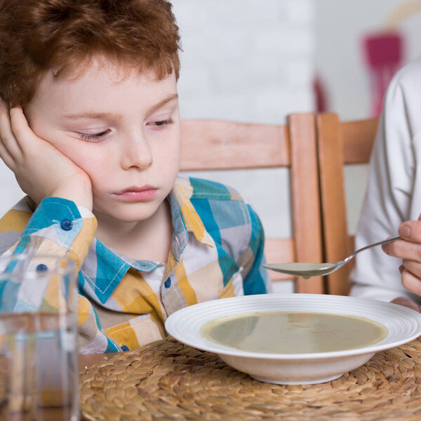 Бедный едок сидит за столом
