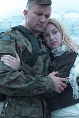 Üzgün asker endişeli karısı kucaklayan