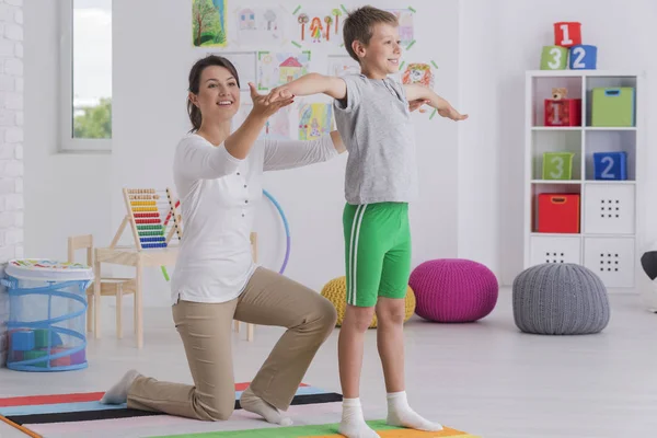 Fysiotherapeut uitoefenend met een school-jongen — Stockfoto