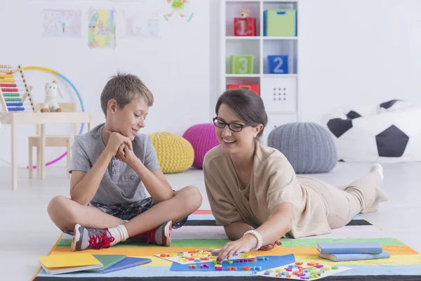 Babysitter playing with a school-boy — Stock Photo, Image