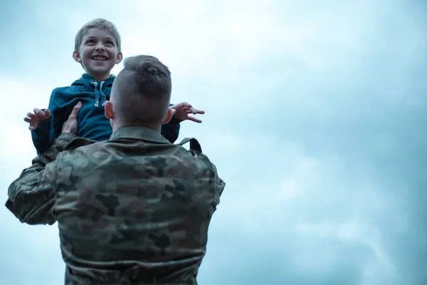 Soldaat met zijn zoon in zijn armen — Stockfoto
