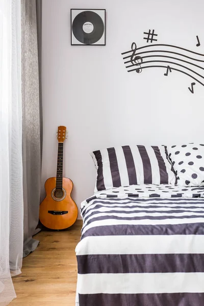 Υπνοδωμάτιο με μια κιθάρα δίπλα στο κρεβάτι — Φωτογραφία Αρχείου