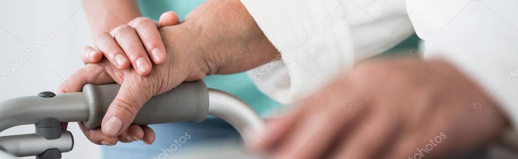 Elderly hands holding the walker