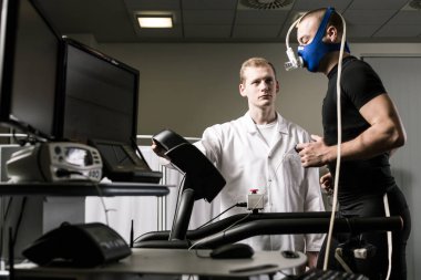 Doctor monitoring man on treadmill clipart
