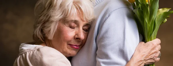 Пожилая женщина обнимается с партнером — стоковое фото