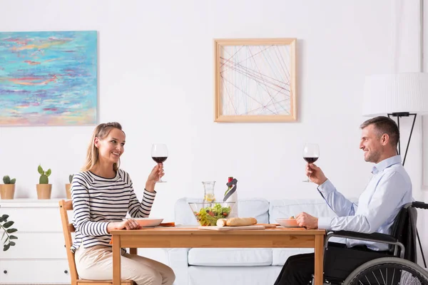 Hombres en silla de ruedas brindan durante la cena — Foto de Stock