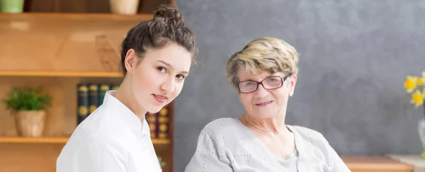 Junge Krankenschwester und Seniorin — Stockfoto