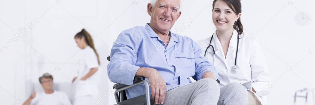Elderly smiling man on wheelchair