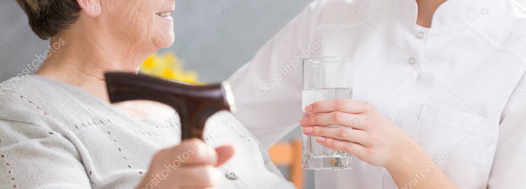 Glass of water for elderly woman