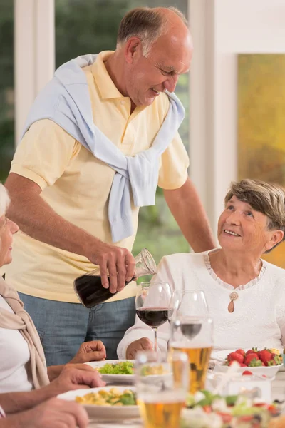 年配の男性がワインを注ぐ — ストック写真