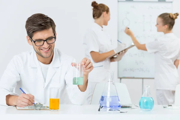 Jovem cientista anotando suas descobertas — Fotografia de Stock