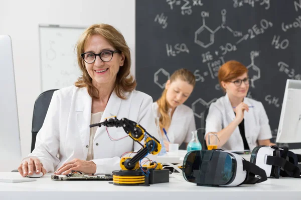 S úsměvem profesor sedí v učebně — Stock fotografie