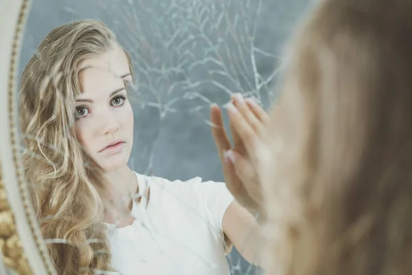 Отражение женщины в разбитом зеркале — стоковое фото