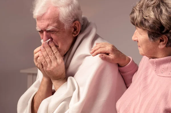Ανώτερος γυναίκα και άρρωστος άνθρωπος με ένα κρύο — Φωτογραφία Αρχείου