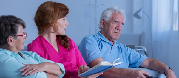 Vrouw leest voor oudere mensen — Stockfoto