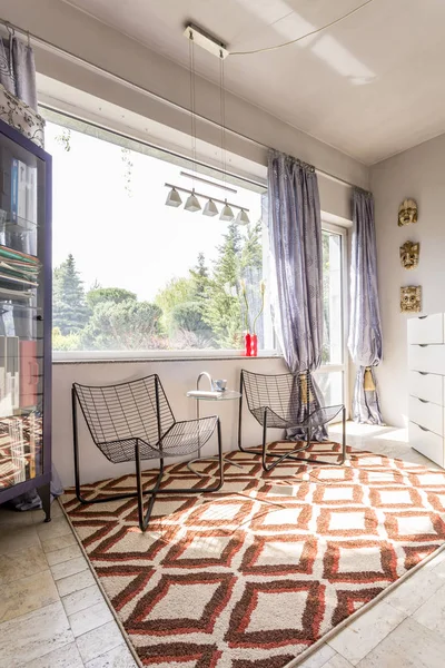 Habitación con sillas minimalistas y alfombra étnica — Foto de Stock