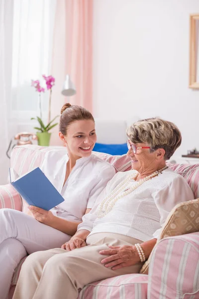Senior patient and nurse with book — Stock Photo, Image
