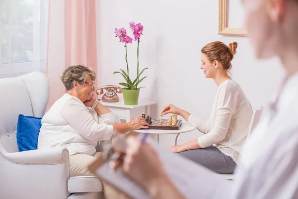 Kvinna som spelar schack med mor — Stockfoto