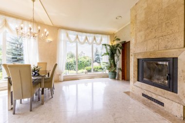 Sandalyeler ve şömine ile açık yemek alanı