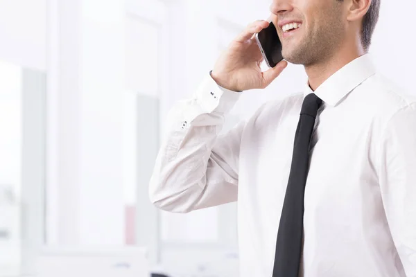 Lachende jonge zakenman aan de telefoon — Stockfoto