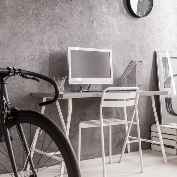 Grey minimalist room with black bike