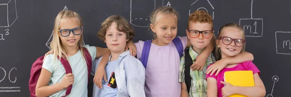 Kinder stehen auf Kreidetafel Hintergrund — Stockfoto