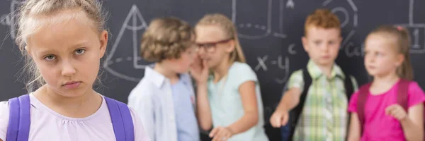 Trauriges Schulmädchen, Kinder, die sie hinters Licht führen — Stockfoto