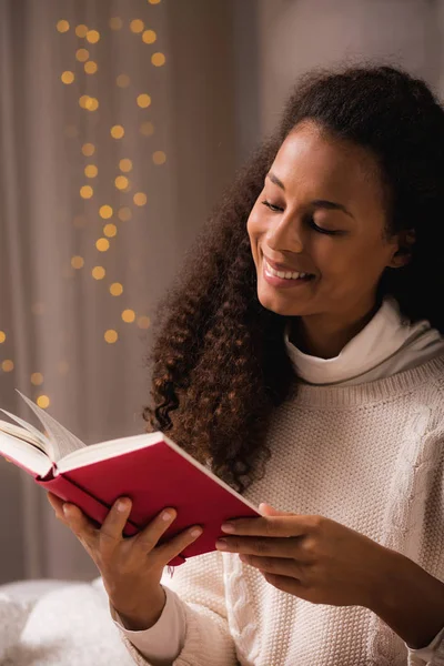 Mulher passando a noite de inverno lendo um livro — Fotografia de Stock