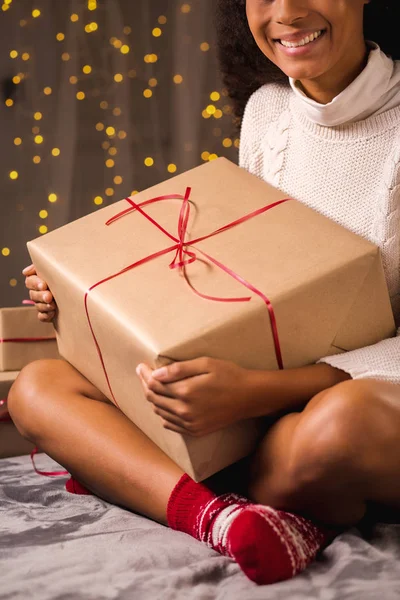Young woman sitting on a floor with present on her lap — Stock Photo, Image