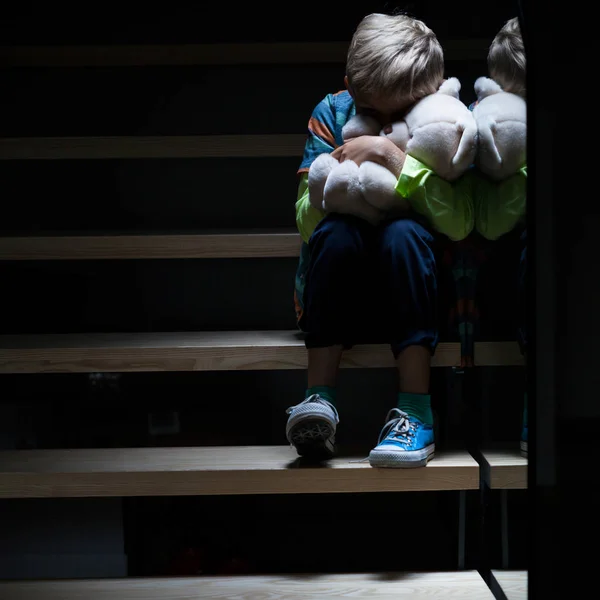 Scared alone boy clutching toy — Stock Photo, Image