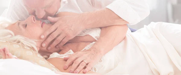 Casamento mais velho beijando na cama — Fotografia de Stock